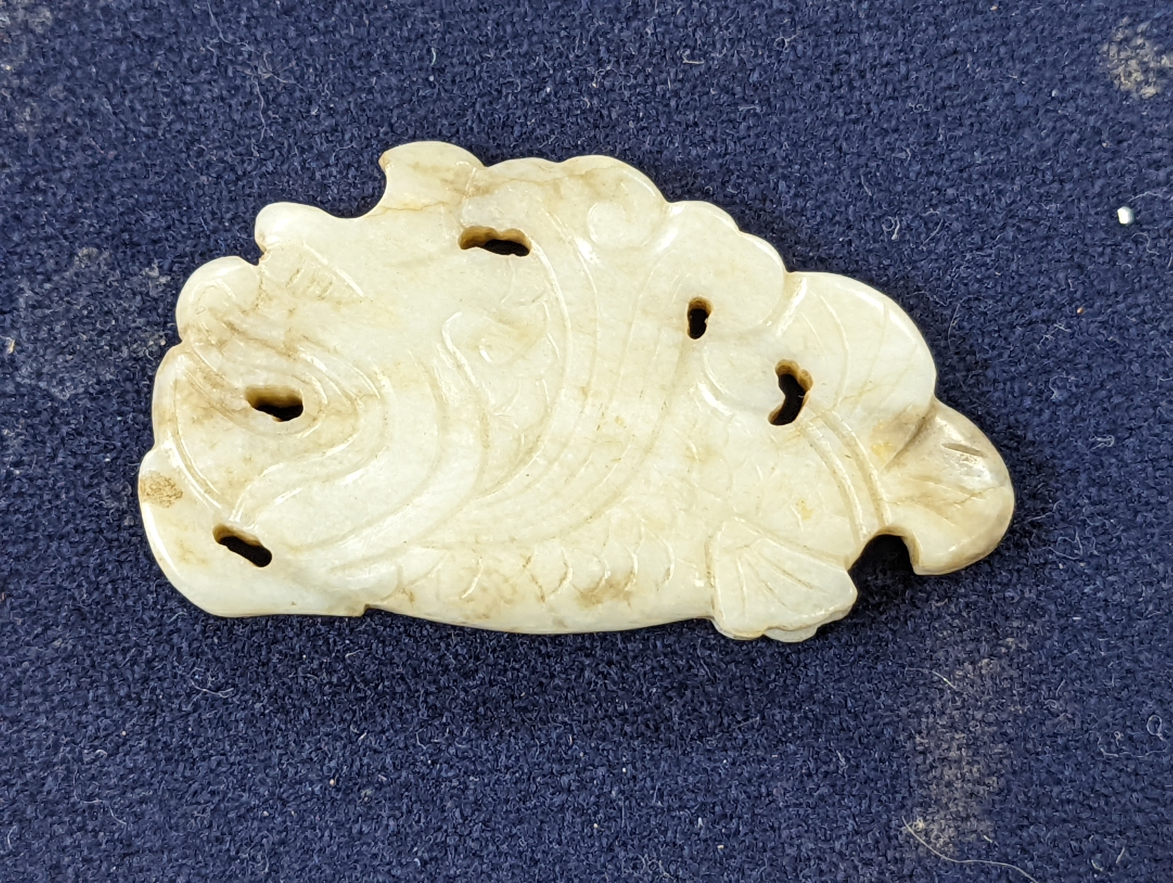 A Chinese white and black jade ‘dragon-fish’ plaque, 19th/20th century, 6cm